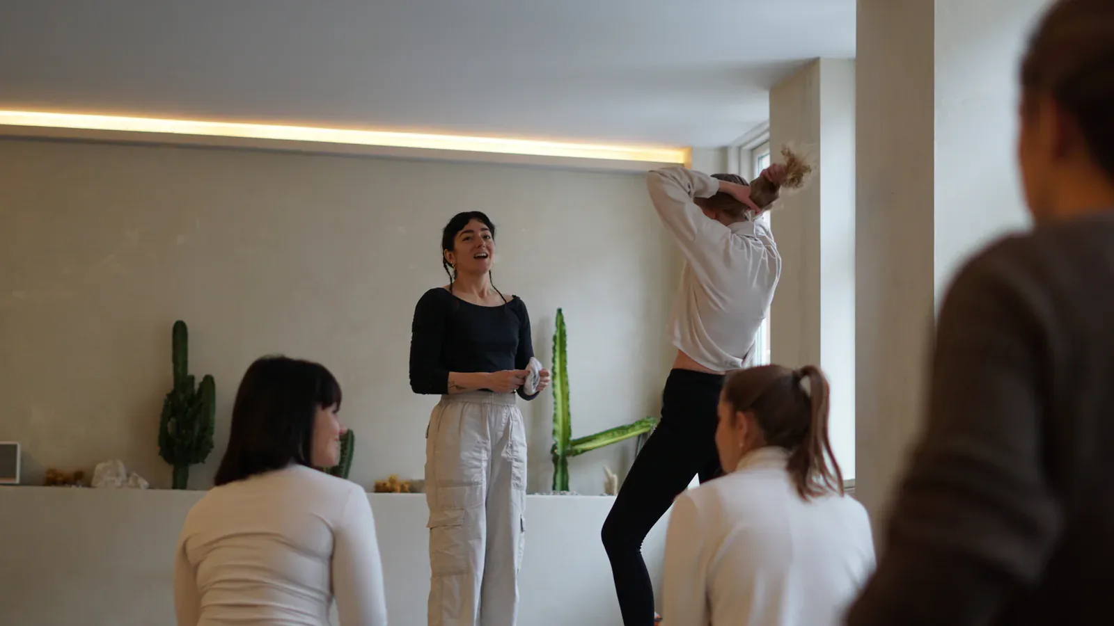 Ioanna smiler, mens hun guider et yogahold