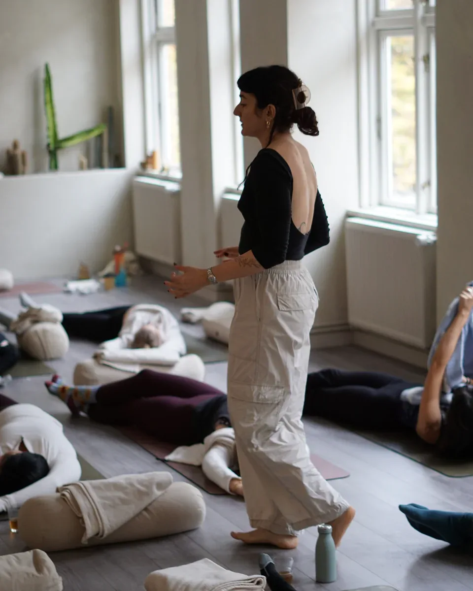 Ioanna guider elever gennem en rolig yogapraksis i studiet
