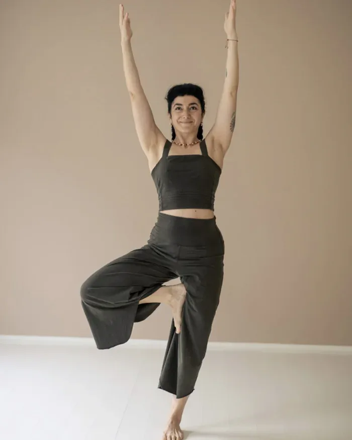 Ioanna holding tree pose in a sunlit studio