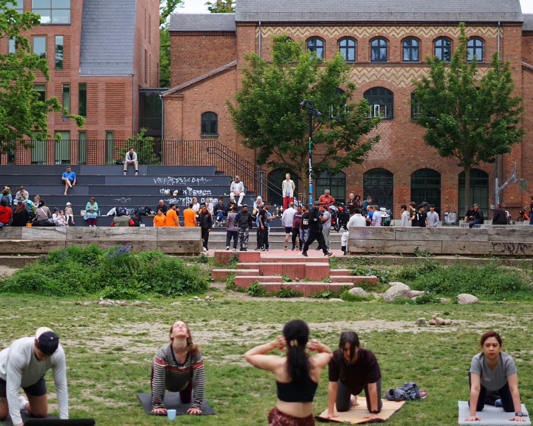 An outdoor group yoga session in a city square